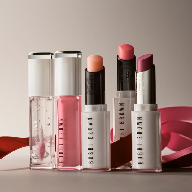 Close up of model applying Crushed-Oil Infused Gloss to lips