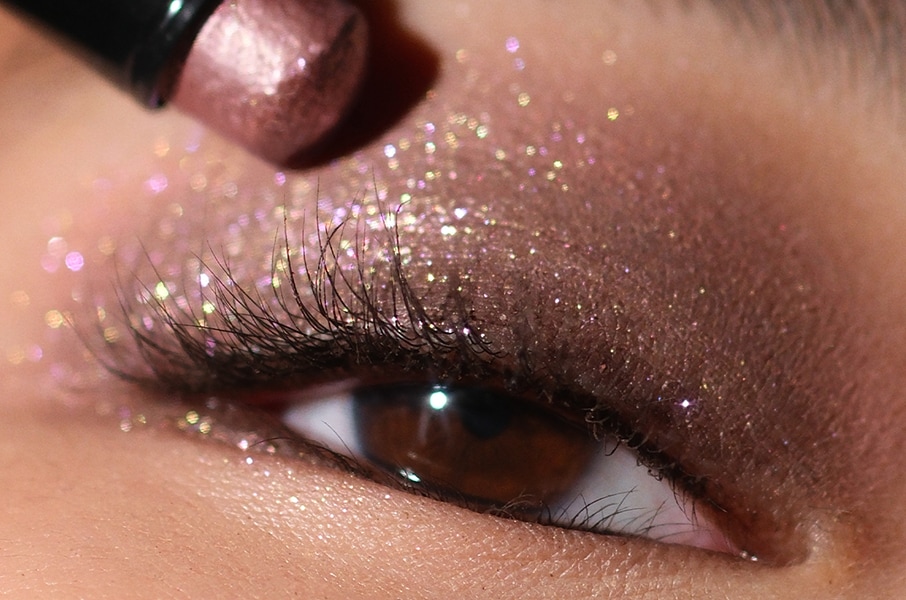 Close up of model eye showcasing defined brows and a natural, shimmery eye look