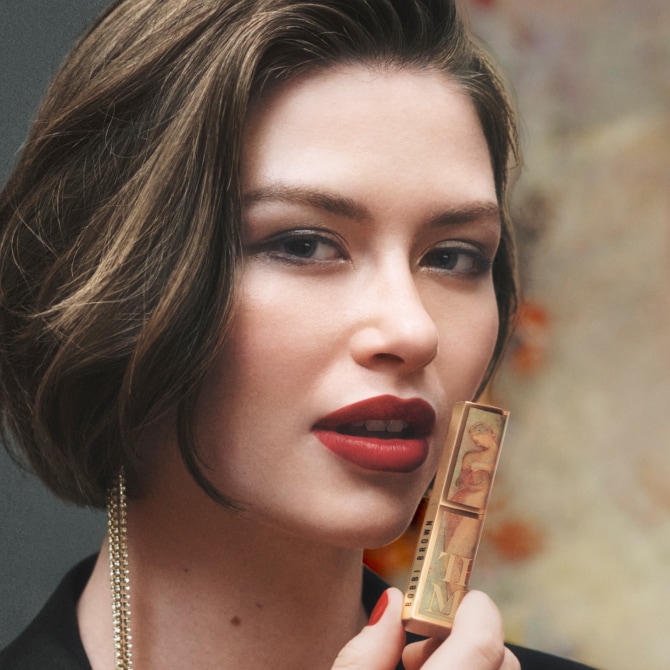 Close up of model applying Crushed-Oil Infused Gloss to lips